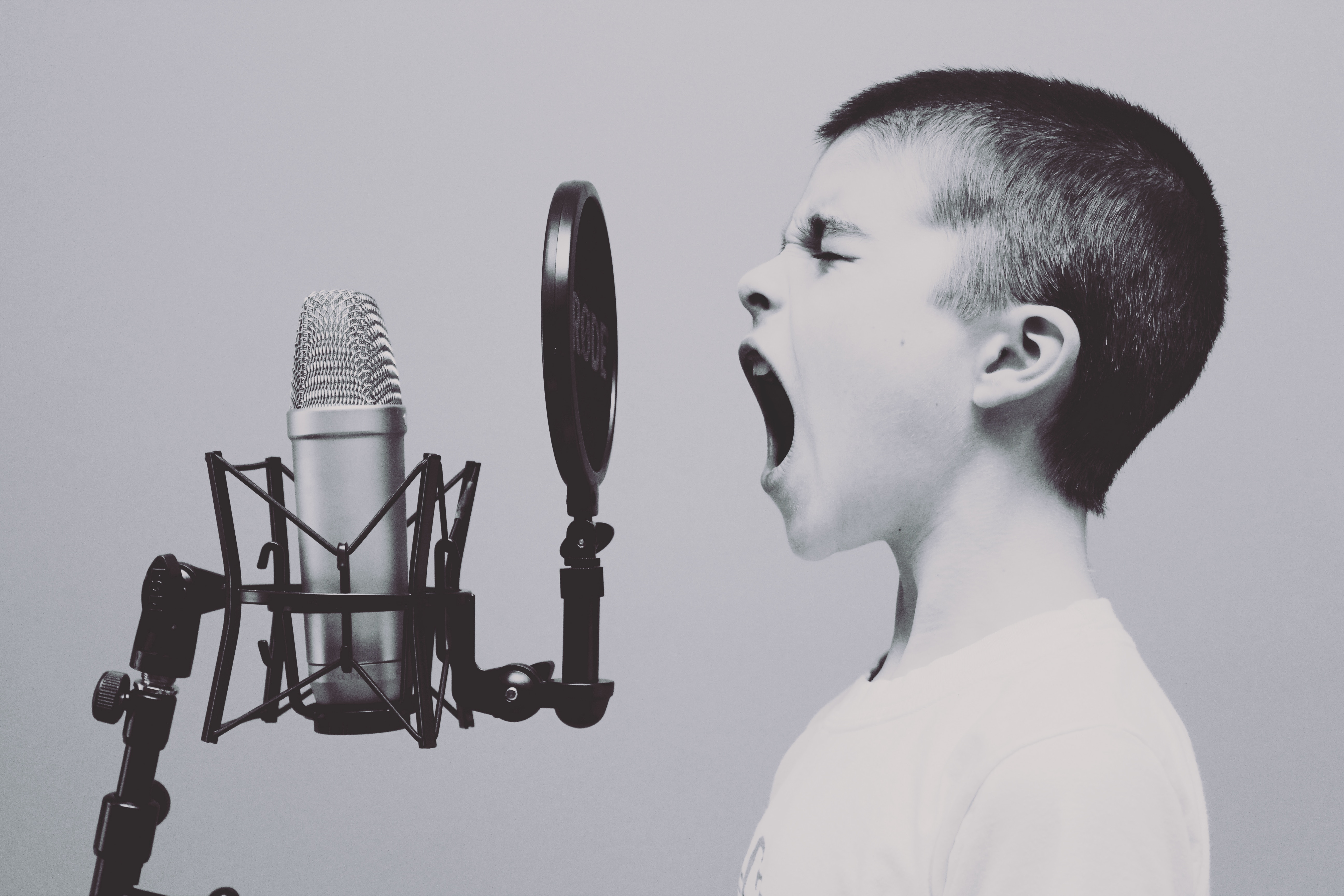 Boy screaming into microphone. Sell voiceover services online.