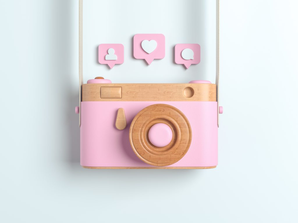 Vintage pink wooden photo camera with Pin heart, friends, comment, post. Overhead view of Traveler's accessories, Flat lay photography of Travel concept. white isolated background. 3d render