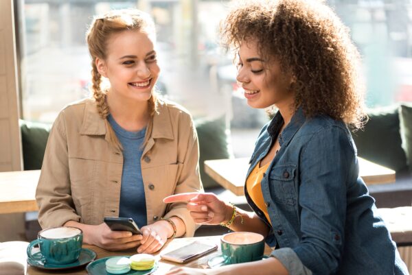 woman showing another woman something on her phone